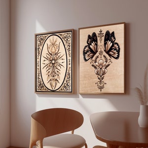 May include: Two framed wood burned art prints. The first print features a stylized floral design with a butterfly. The second print features a butterfly with a floral design.