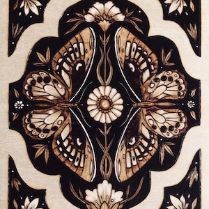 May include: A woodburned design featuring four butterflies with intricate details, surrounded by stylized flowers and leaves. The design is on a dark background with white accents.