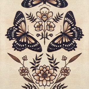 May include: A woodburned design of three butterflies and flowers. The butterflies are black with white spots and the flowers are brown with white centers.
