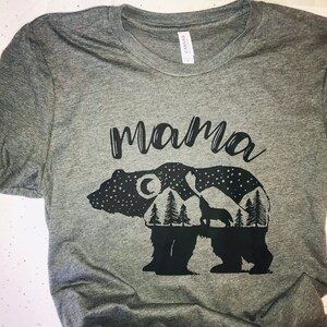 May include: Gray t-shirt with a black graphic of a bear with a mountain range, moon, and stars inside. The text "mama" is above the bear.