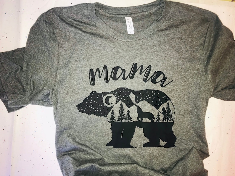 May include: Gray t-shirt with a black graphic of a bear with a mountain range, moon, and stars inside. The text "mama" is above the bear.