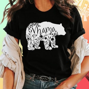 May include: Black t-shirt with a white floral bear silhouette and the word "Mama" inside the bear.
