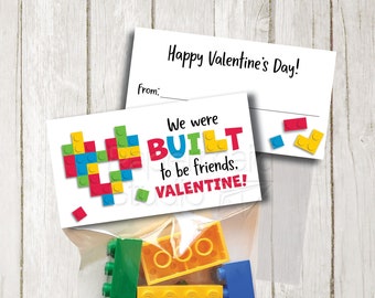 May include: A printable Valentine's Day card with a heart made of colorful Lego bricks. The card says "We were BUILT to be friends. VALENTINE!" and includes a blank space for a name. The card is accompanied by a small bag of Lego bricks.