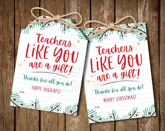 May include: Two printable gift tags with a Christmas theme. The tags feature a green and red pine branch design with the text "Teachers Like You Are A Gift!" and "Thanks for all you do!" One tag says "Happy Holidays!" and the other says "Merry Christmas!"