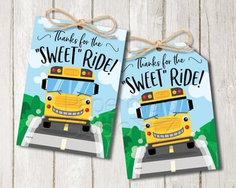 Puede incluir: Dos etiquetas de favor de autobús escolar amarillo con el texto "Thanks for the "SWEET" RIDE!" impreso en ellas. El autobús tiene una cara sonriente y las palabras "School Bus" impresas en el lateral. Las etiquetas están sobre un fondo de madera.