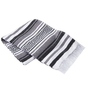 May include: A black and white striped Mexican blanket with fringe. The blanket has a geometric pattern in the center.