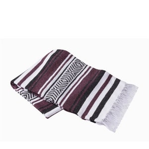 May include: A purple, black, and white striped Mexican blanket with fringe on the edges.