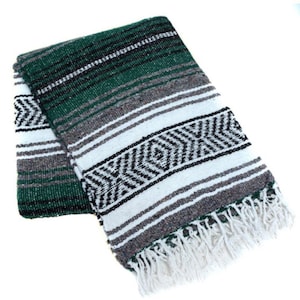 May include: A green, white, and black striped Mexican blanket with fringe. The blanket is folded in half and has a traditional pattern.