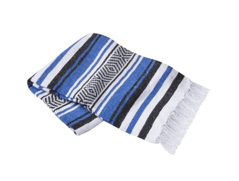 May include: A blue, white, and black striped Mexican blanket with fringe. The blanket is folded in half and has a geometric pattern.