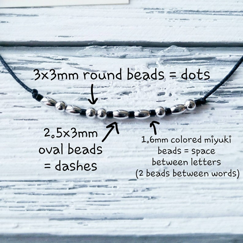 Puede incluir: Primer plano de un cord&oacute;n negro con cuentas plateadas. Las cuentas son redondas de 3 mm y ovaladas de 2,5 x 3 mm. El texto dice "3x3mm cuentas redondas = puntos", "2,5x3mm cuentas ovaladas = guiones", "1,6 mm cuentas miyuki de colores = espacio entre letras (2 cuentas entre palabras)".