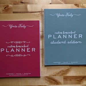 May include: Two spiral-bound homeschool planners. One is burgundy with "Yours Truly" and "custom homeschool PLANNER" printed in white. The other is teal with "Yours Truly" and "custom homeschool PLANNER student edition" in white.