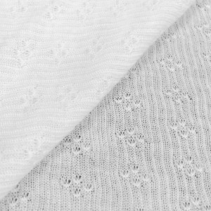 May include: Close-up of two white knitted fabrics with different patterns. The top fabric has a simple, straight pattern, while the bottom fabric has a more intricate, diamond-shaped pattern.