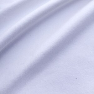 May include: White fabric with a smooth texture and a slight sheen. The fabric is folded and draped, creating soft folds and curves.