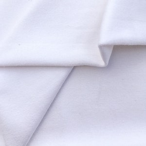 May include: White fabric folded in half, showing the texture of the material.