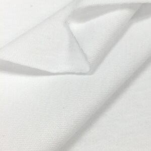 K&ouml;nnte beinhalten: Wei&szlig;er Baumwollstoff mit einer strukturierten Webart. Der Stoff ist in der Mitte gefaltet und zeigt die Innenseite und Au&szlig;enseite des Materials.
