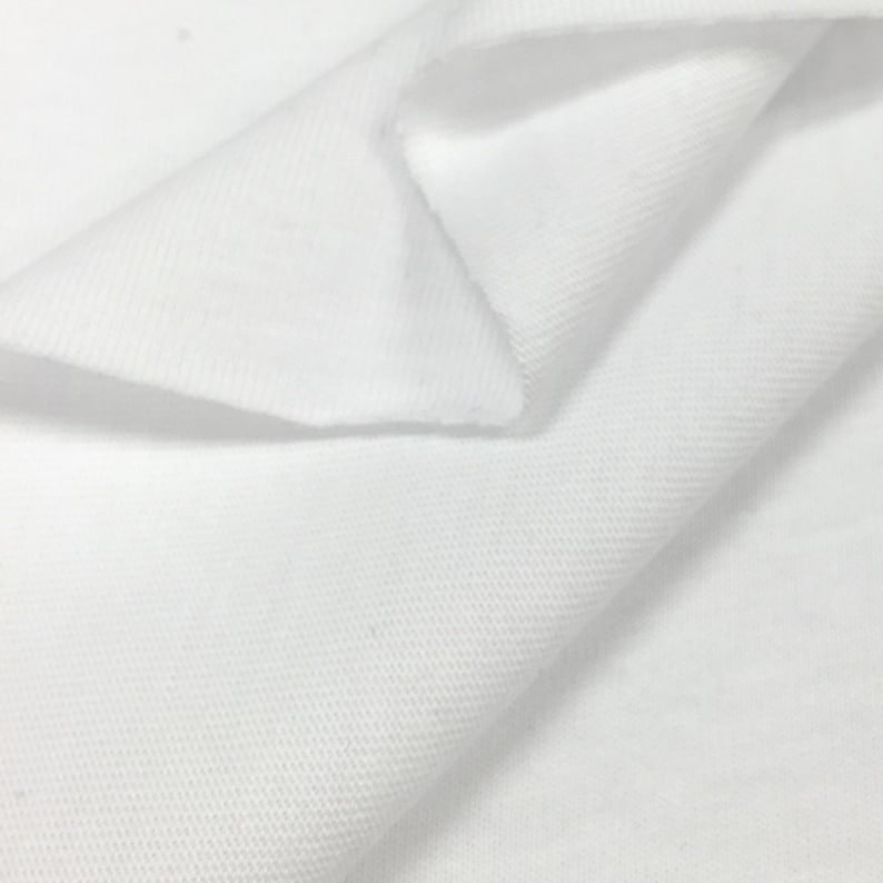 K&ouml;nnte beinhalten: Wei&szlig;er Baumwollstoff mit einer strukturierten Webart. Der Stoff ist in der Mitte gefaltet und zeigt die Innenseite und Au&szlig;enseite des Materials.