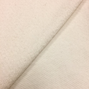 May include: Close-up of a white fabric with a soft, fuzzy texture. The fabric is folded in half, showing both sides.