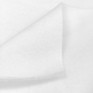 May include: Close-up of white fabric with a textured surface. The fabric is folded over itself, showing the inside of the material.