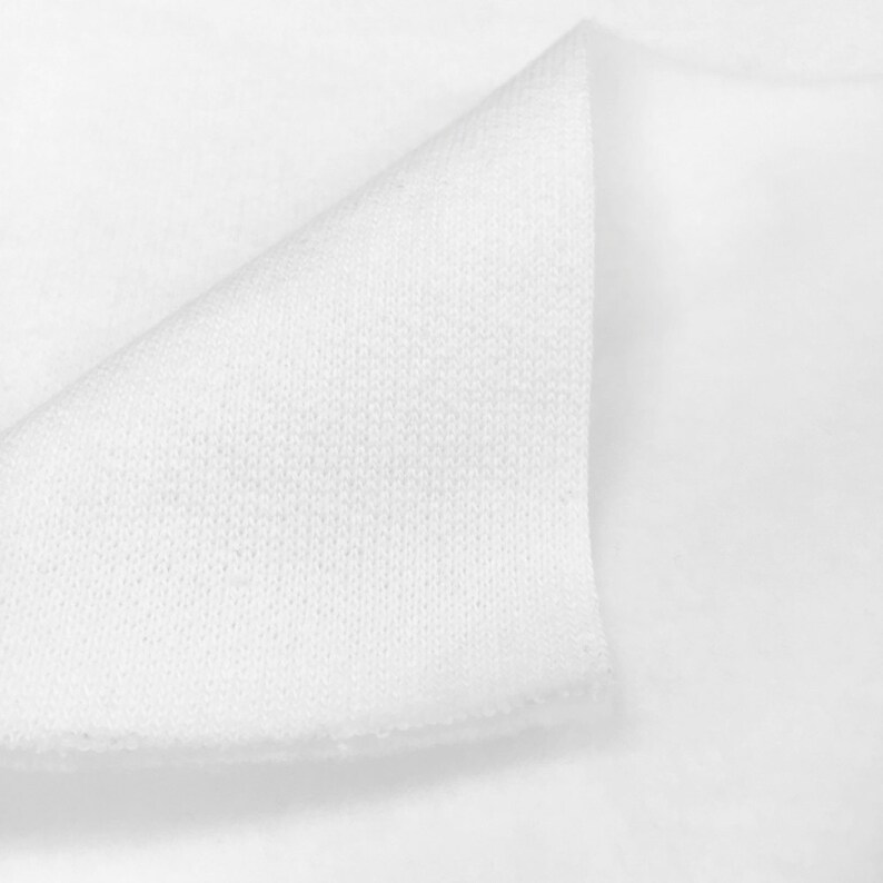 May include: Close-up of white fabric with a textured surface. The fabric is folded over itself, showing the inside of the material.