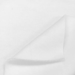 May include: Close-up of a white fabric with a textured surface. The fabric is folded in half, showing the inside of the fabric.