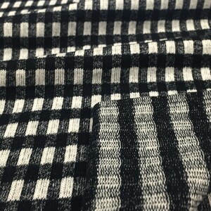 May include: Black and white checkered fabric with a black and white striped pattern.