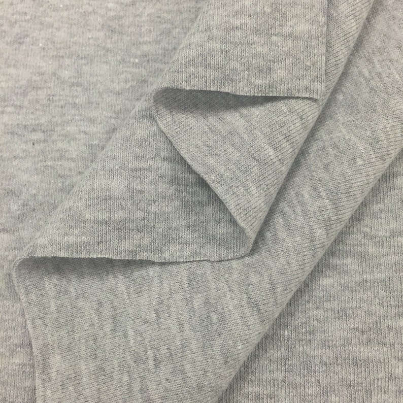 May include: Close-up of a gray, textured fabric with a ribbed pattern. The fabric is folded in a way that shows the texture and the weave.