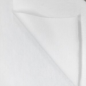 K&ouml;nnte beinhalten: Wei&szlig;er Stoff mit einer strukturierten Oberfl&auml;che. Der Stoff ist in der Mitte gefaltet und zeigt die Innenseite und Au&szlig;enseite des Materials.