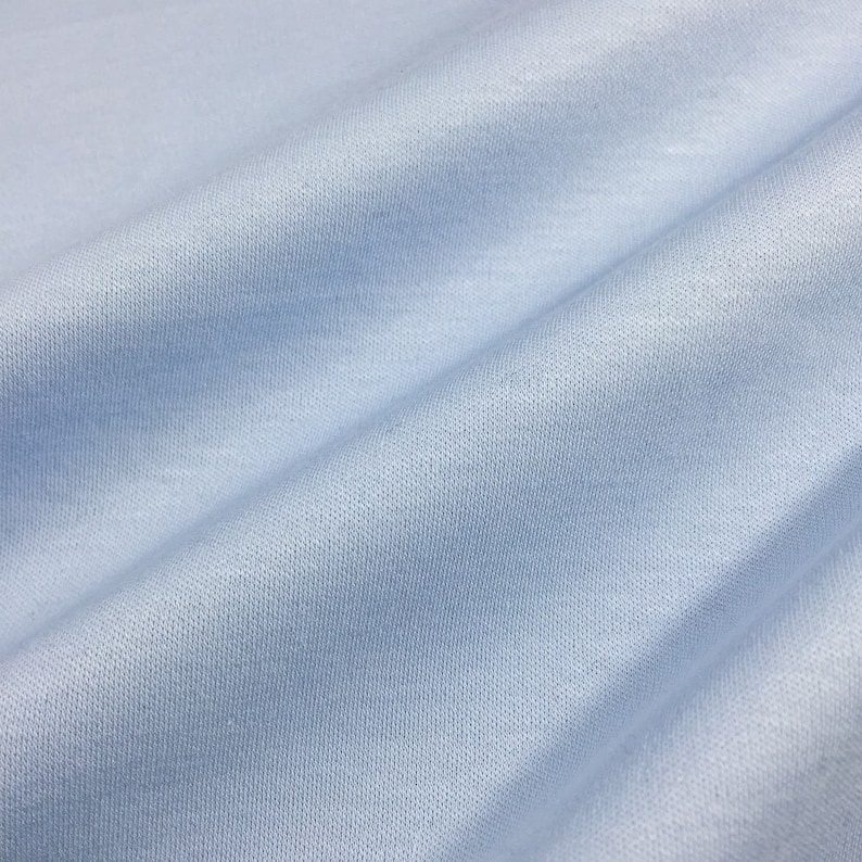 May include: A close-up of a light blue fabric with a textured surface.