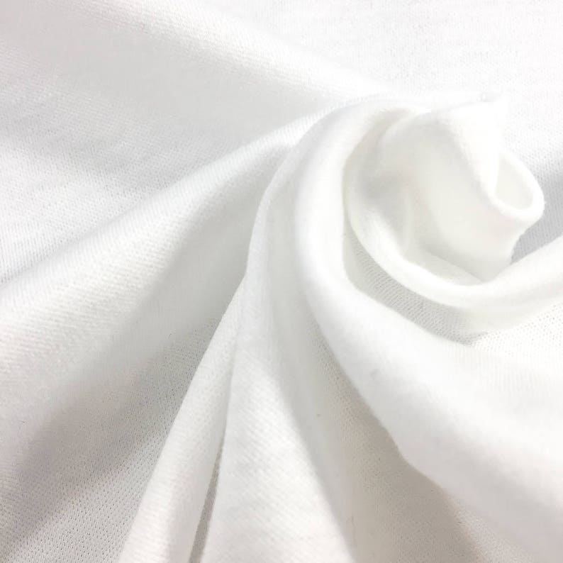 May include: White fabric with a smooth texture, folded and draped in a soft, flowing manner.
