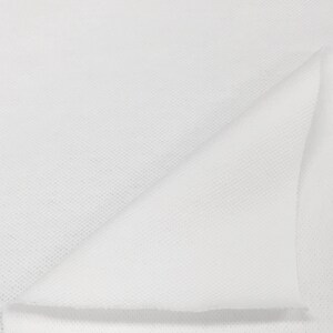 K&ouml;nnte beinhalten: Wei&szlig;es Vliesstoff, in der H&auml;lfte gefaltet, zeigt die Textur des Materials.
