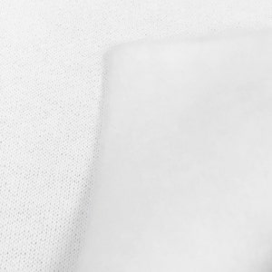 May include: White fabric with a textured surface. The fabric is smooth and has a subtle sheen.