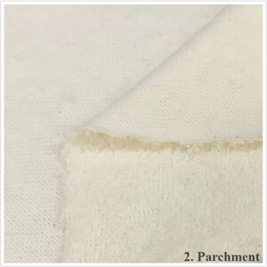 May include: Close-up of a soft, white fabric with a slightly textured surface. The fabric is folded over, revealing a fluffy, white underside. The text "2. Parchment" is visible in the lower right corner of the image.