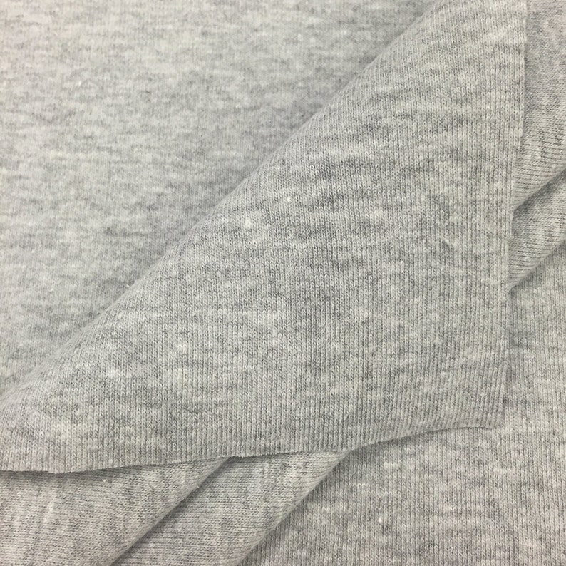 May include: Close-up of a gray, textured fabric. The fabric is folded in half, showing the inside and outside of the material.