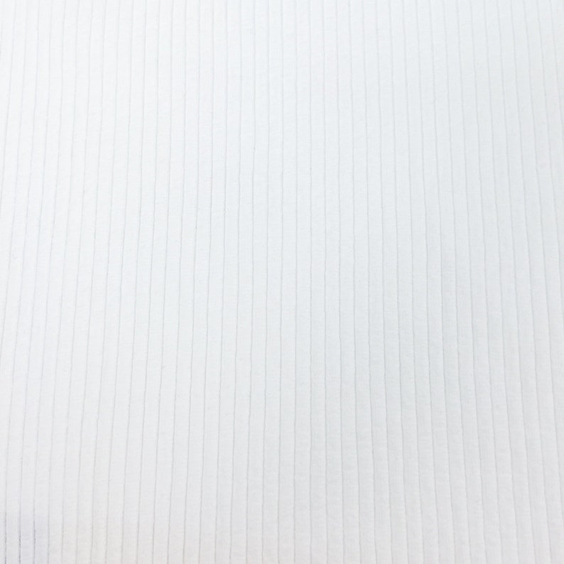 Op de afbeelding: Witte ribbelstof met een verticale textuur. De stof is glad en heeft een subtiele glans.