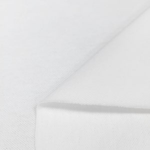 K&ouml;nnte beinhalten: Wei&szlig;er Stoff mit einer strukturierten Oberfl&auml;che. Der Stoff ist in der Mitte gefaltet, wodurch eine Falte entsteht.