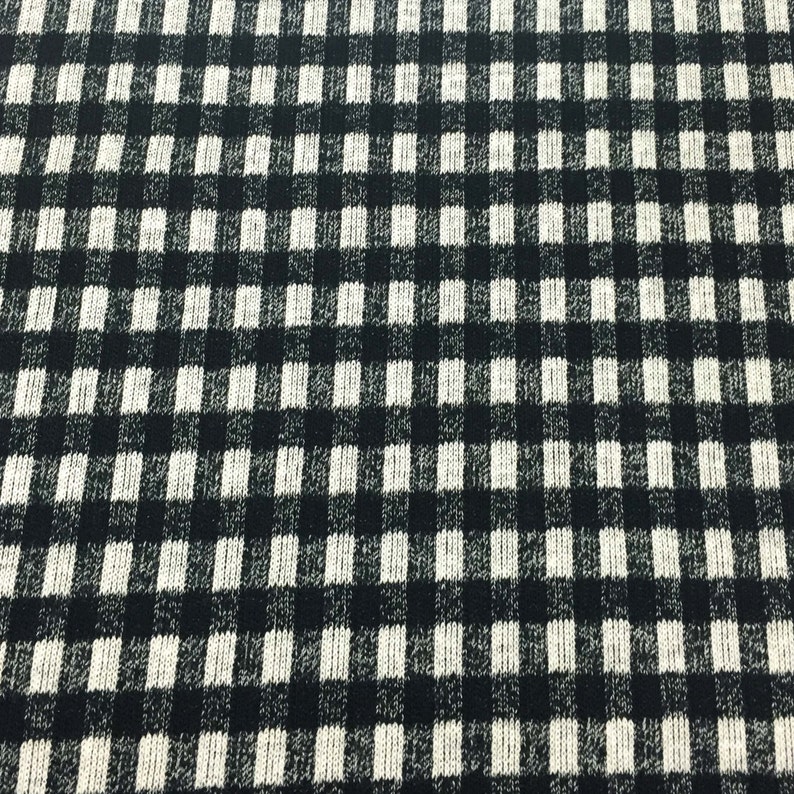 May include: Black and white checkered fabric with a textured knit pattern.