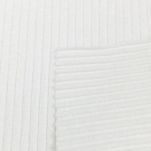 Op de afbeelding: Close-up van witte ribbelstof. De stof heeft een gladde textuur en een subtiele glans.