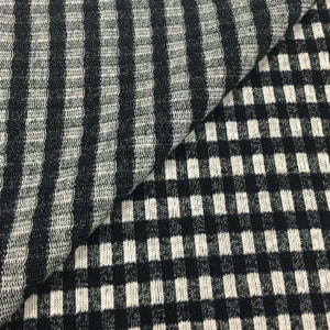 May include: Black and white striped fabric with a black and white checkered pattern.