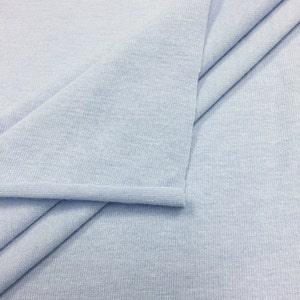May include: A light blue fabric with a ribbed texture. The fabric is folded in half and the edges are sewn.