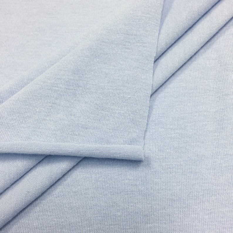 May include: A light blue fabric with a ribbed texture. The fabric is folded in half and the edges are sewn.