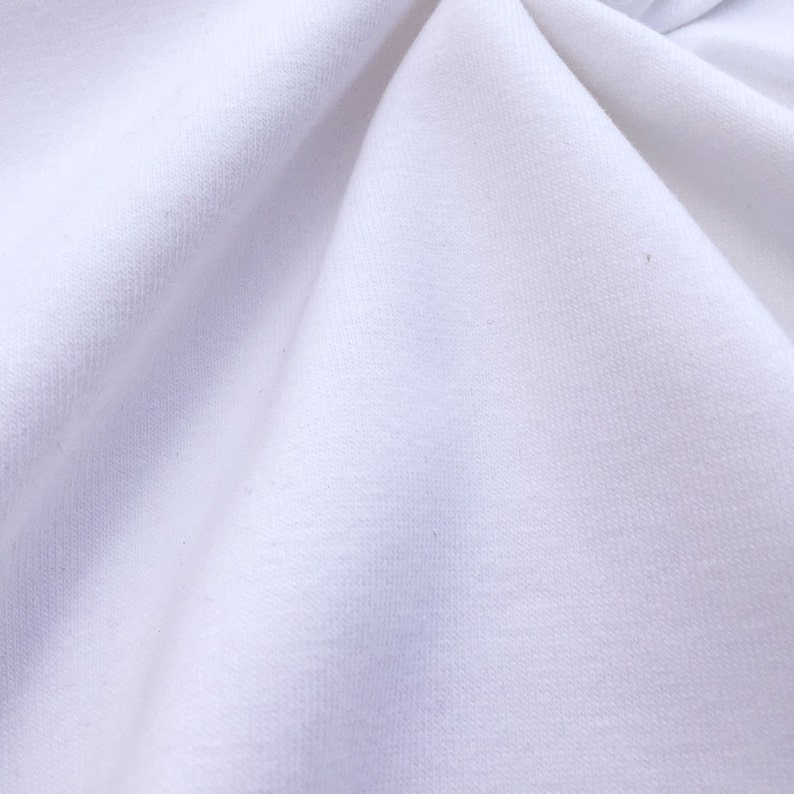 May include: Close-up of a white fabric with a smooth texture. The fabric is wrinkled and has a slight sheen.