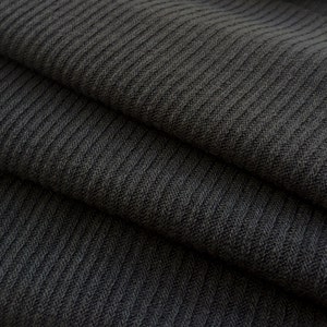 May include: Close-up of dark gray ribbed fabric. The fabric is folded in layers, showing the texture of the knit.