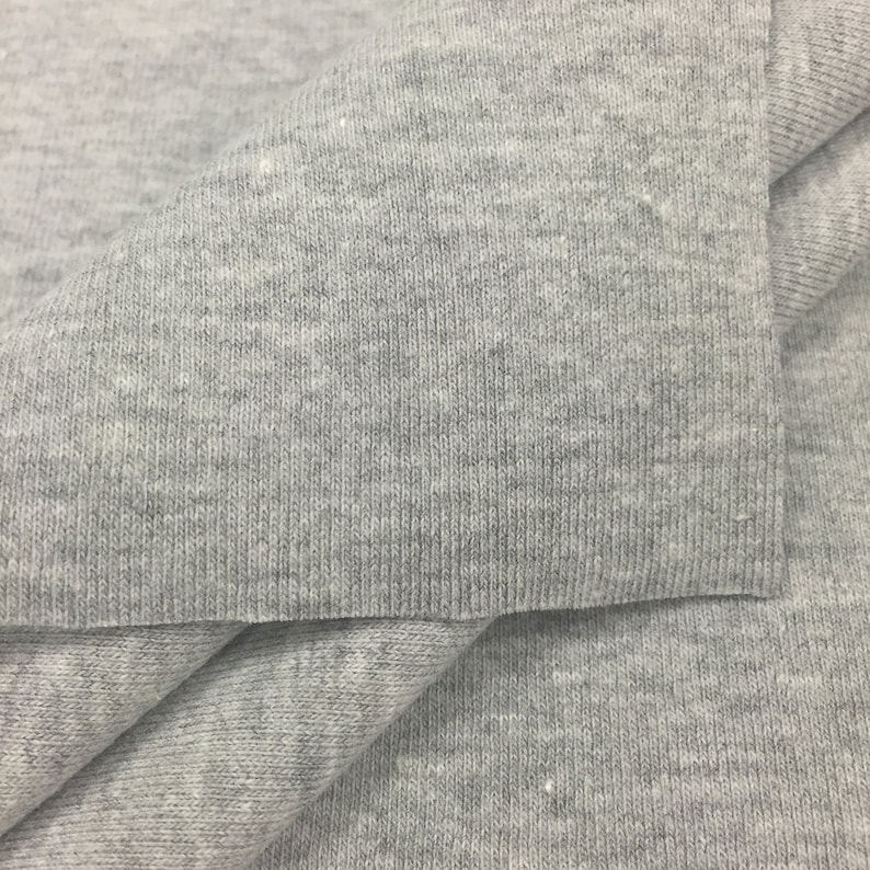 May include: Close-up of a gray, textured fabric. The fabric is folded in half, showing the inside and outside of the material.