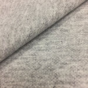 Puede incluir: Primer plano de una tela gris texturizada. La tela tiene un aspecto suave y peludo.