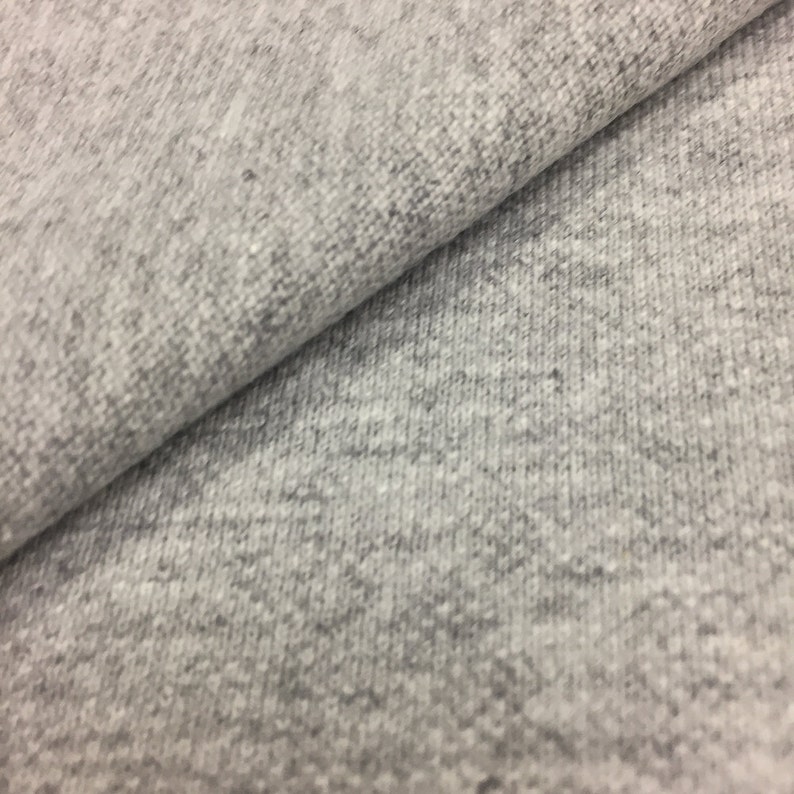 Puede incluir: Primer plano de una tela gris texturizada. La tela tiene un aspecto suave y peludo.