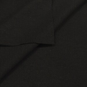 May include: Black ribbed knit fabric. The fabric is folded in half, showing the texture of the knit.
