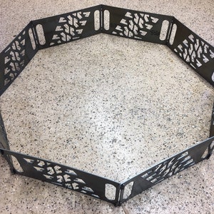 May include: A black metal fire pit ring with a geometric pattern cut out. The ring is made of eight sections that can be assembled to form a circle.