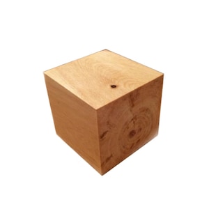 May include: A solid wood cube with a natural wood finish. The cube has a smooth surface and a light brown color.