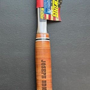 May include: A 20 oz. Estwing hammer with a polished steel head and a brown leather handle. The handle is engraved with "JOSEPH BDN". A tag with the American flag is attached.