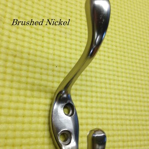 Puede incluir: Gancho para abrigos de n&iacute;quel cepillado con dos agujeros. El gancho es curvo y tiene un acabado liso.